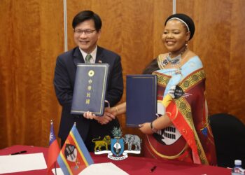 Eswatini and Taiwan officials shake hands after signing a pact to combat disinformation.