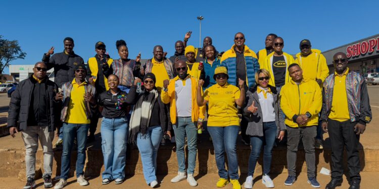 MTN Eswatini CEO Wandile Mtshali joins frontline staff for a group photo during the final stop of the nationwide roadshow in Nhlangano.