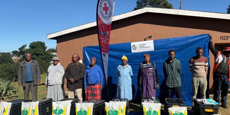 A Red Cross volunteer hands over a food parcel to an elderly recipient during a donation ceremony in Nkilongo.