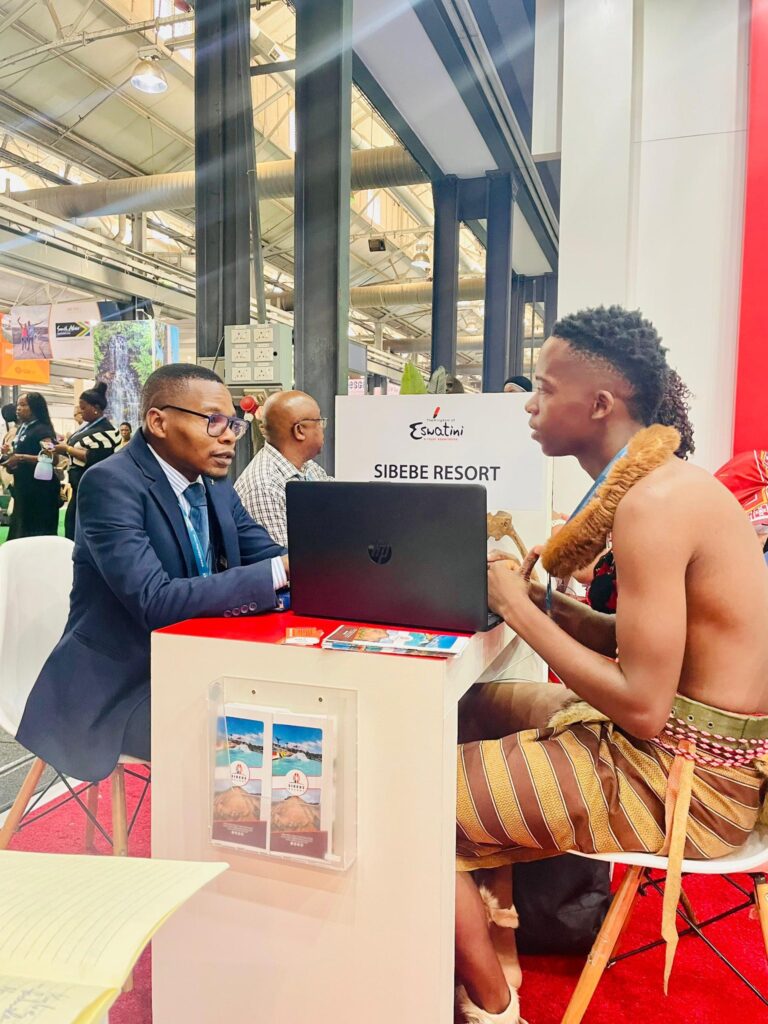 Simelane engaging with a visitor at the Sibebe Resort exhibition desk during Africa’s Travel Indaba, showcasing Eswatini’s premier all-in-one tourism destination.