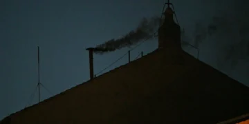 This photograph shows black smoke rising from the chimney of the Sistine Chapel signalling that cardinals failed to elect a new pope in the first ballot of their conclave in the Vatican on May 7, 2025. (Photo by Andreas SOLARO / AFP)