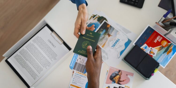 A traveller hands over his passport with a flight ticket tucked inside