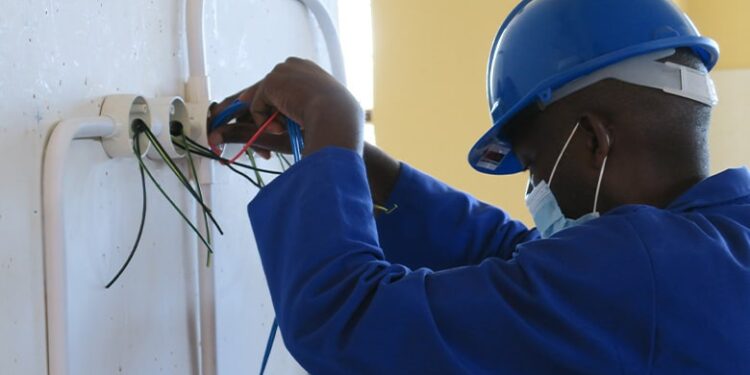 An electrician carefully installing wiring during a job on-site
