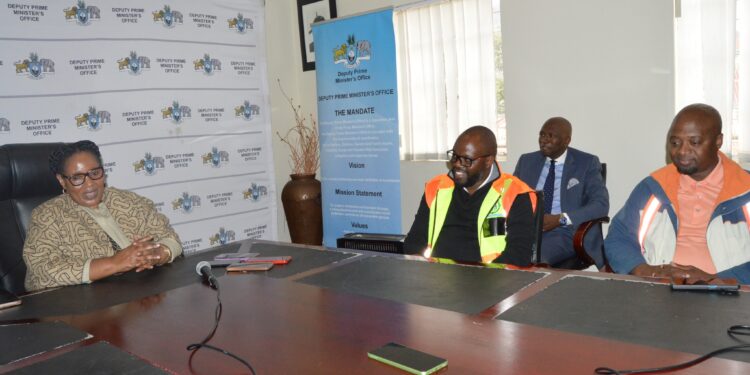 Acting Prime Minister Thulisile Dladla receives 20 bags of cement from Dual M Investment Director Muzi Mamba and Site Agent Phesheya Mnisi to support the construction of Mlulami Dlamini’s home in KaMagele, Hlatsi.