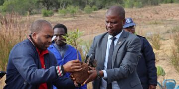 Minister of Agriculture Mandla Tshawuka plants a tree alongside community members during UNCCD Day commemorations at Sigcaweni under Gilgal Inkhundla.