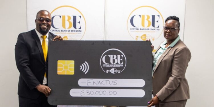 Deputy Governor of the Central Bank of Eswatini, Felicia Dlamini-Kunene, hands over a cheque to Sabelo Dlamini, the newly appointed Country Leader of Enactus Eswatini, during the CSI handover ceremony held in Mbabane.