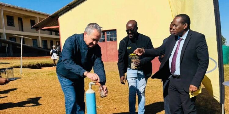 Standard Bank Eswatini CEO and MTN Eswatini CEO take the first sip from the newly installed solar-powered borehole at Mkhuzweni Primary School.