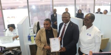 Minister of Commerce, Industry and Trade Manqoba Khumalo shares a moment with a customer who just received her trading licence at the BOSS centre in Mbabane.