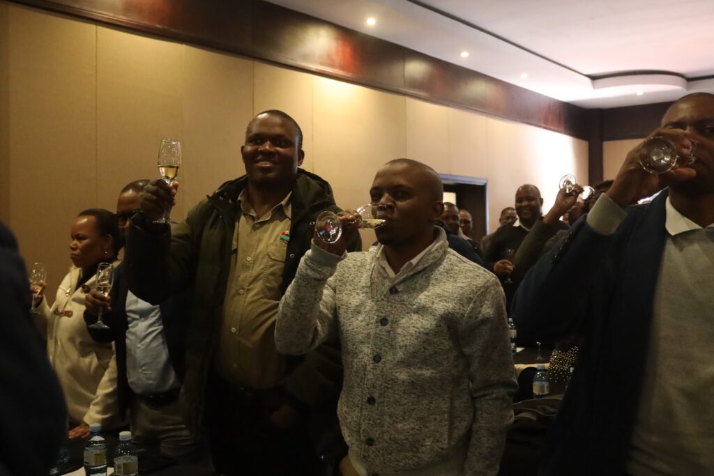 EWADE staff raise their glasses in unison during the mid-term Vusela, celebrating collective achievements in the organisation’s strategic journey.