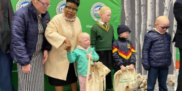 Minister Jane Mkhonta Simelane hands over a sun protection kit to a learner living with albinism during the launch of the “Safe Skin, Bright Future” campaign in Mbabane.