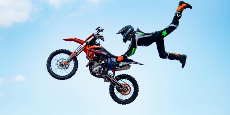 A stunt biker from Jungle Rush FMX catches massive air during a jaw-dropping freestyle motocross performance.