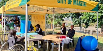 A participant with a disability engages with consultants during the Eswatini Career Expo 2025 at Mavuso Trade Centre.
