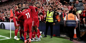 Liverpool players celebrate a hard-fought opening day victory at Anfield.