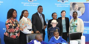 Two learners with disabilities pose for a photo alongside Ministry of Health officials and representatives from UNICEF and the European Union during the assistive devices handover.