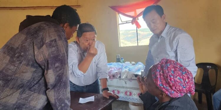 A visiting doctor attends to a patient during a medical outreach session.