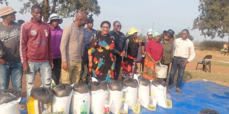 Deputy Prime Minister Senator Thulisile Dladla and World Vision Eswatini’s National Director Amos Zaindi pose with community members and some of the food distributed during the Shewula relief initiative.
