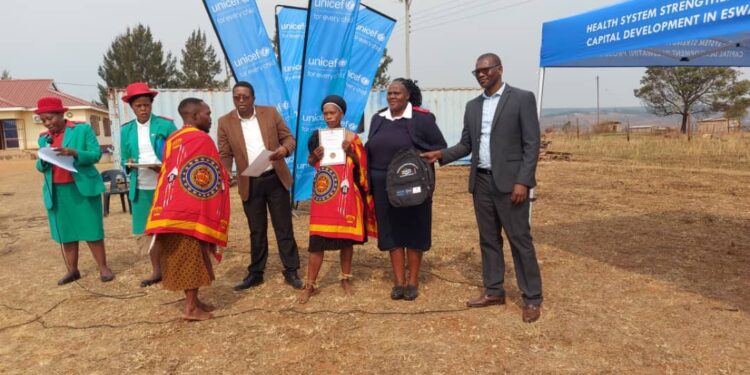 A newly trained Rural Health Motivator receives his certificate during the graduation ceremony in Mahlalini.