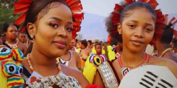 Maidens gather and carry reeds to the Queen Mother during the traditional Umhlanga Reed Dance, showcasing Swazi culture and unity.