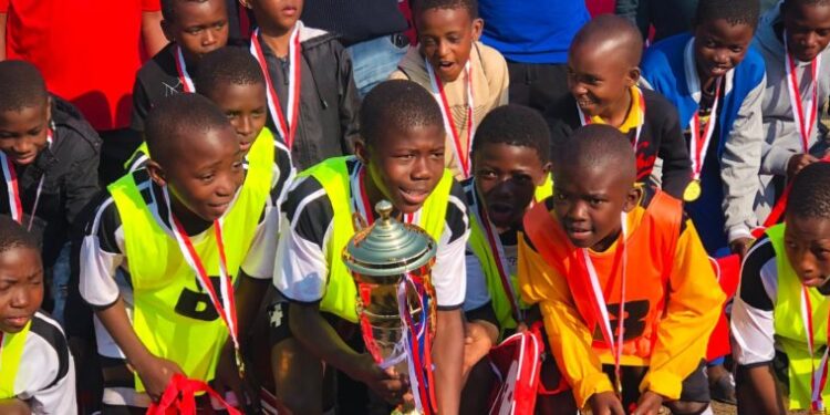 Mshinande Arsenal players celebrate their Build It Piggs Peak U-13 triumph at Killarney Sports Ground.