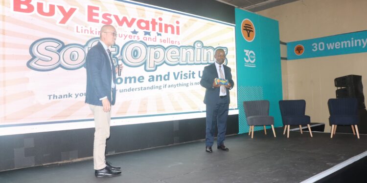 Two officials exchange views on the BuyEswatini 2.0 platform during its soft launch at the trade fair.