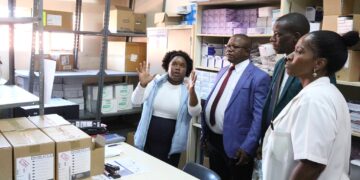 A hospital staff member briefs Ministers Manqoba Khumalo and Bongani Nzima on the current medicine stock levels at Hlathikhulu Government Hospital.