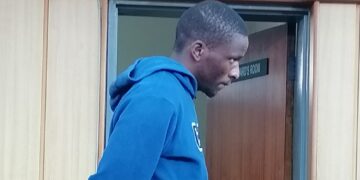 The 24-year-old stands in the dock, his face betraying a mix of remorse and resignation as the sentence is read out.