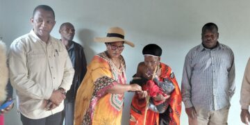 Deputy Prime Minister Thulisile Dladla hands over the keys to one of the newly constructed homes to Juana Nkonde Dlamini in Piggs Peak yesterday.