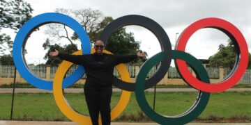 Mrs. Dorothy Tlagae-Gaseitsiwe, CEO of the Botswana National Olympic Committee, poses beside the Olympic rings during her visit to Eswatini.