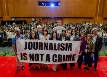 Journalists hold a banner reading "Journalism is not a crime" during the GIJC in Kuala Lumpur, Malaysia. Photo by GIJN