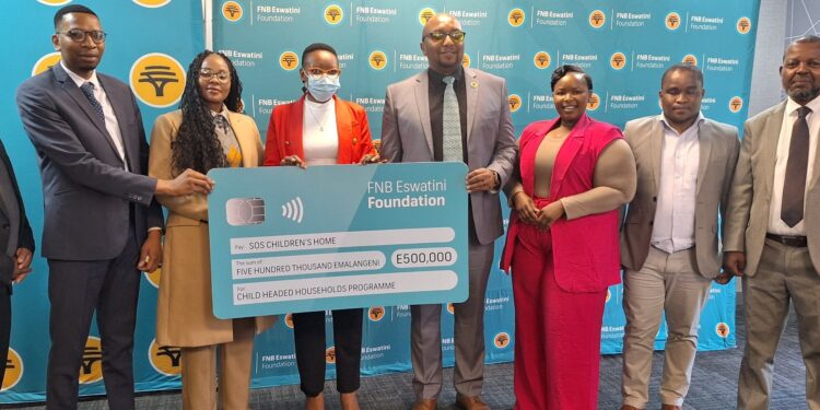 FNB Eswatini CEO Thokozani 'TK' Dlamini presents a E500,000 sponsorship cheque to support SOS Children's Village Child-Headed Households Programme. Photo by FNB Eswatini