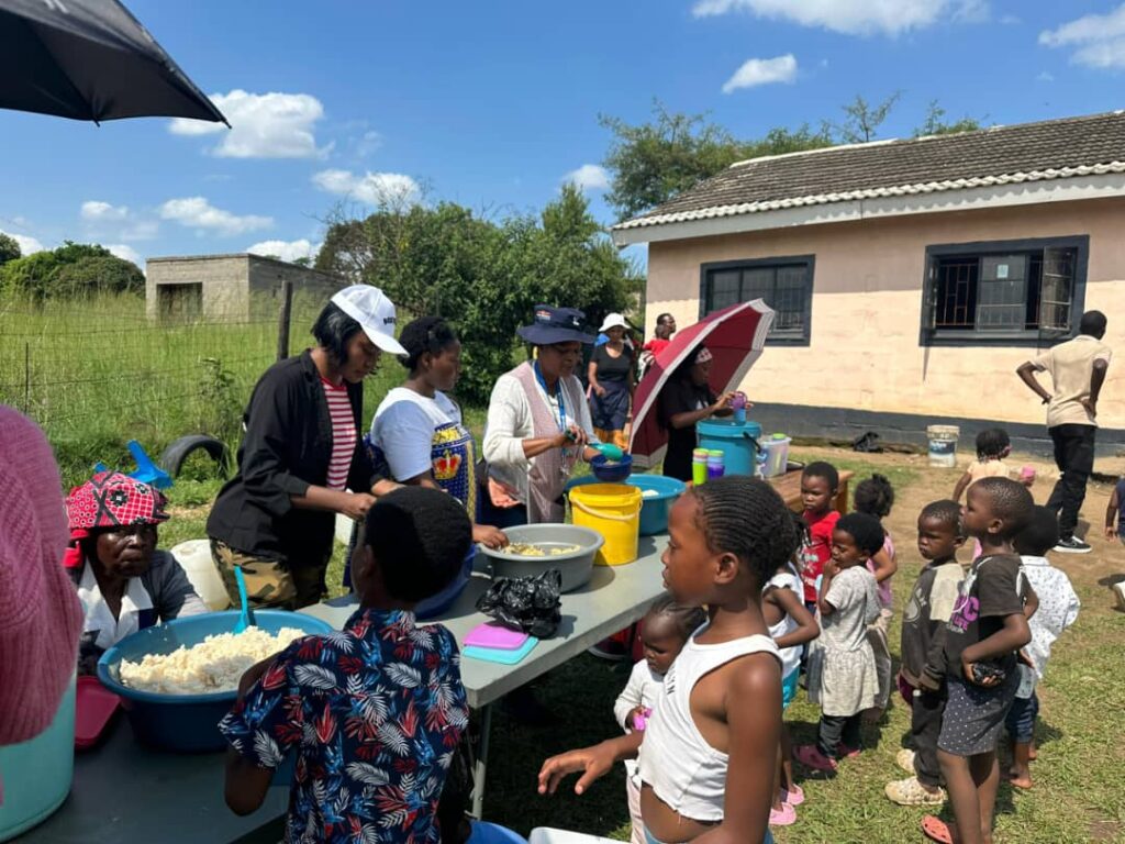Volunteers from One Accord Eswatini serve lunch to children during their charity outreach at Ka-Shali Gogo Centre. Photo credit: One Accord Eswatini