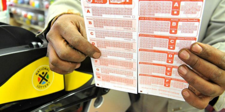A customer holds a freshly purchased Lotto ticket