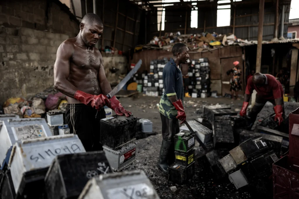 Each night, laborers work in a sort of bucket brigade to load batteries for delivery to the factories.