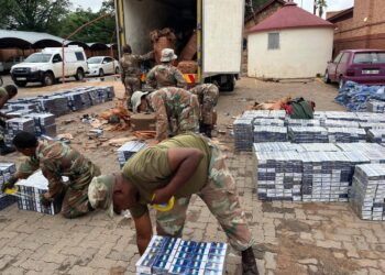 Soldiers from the 1 South African Tank Regiment inspecting the seized illicit cigarettes. Photo by SANDF.