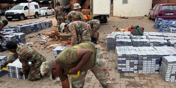 Soldiers from the 1 South African Tank Regiment inspecting the seized illicit cigarettes. Photo by SANDF.