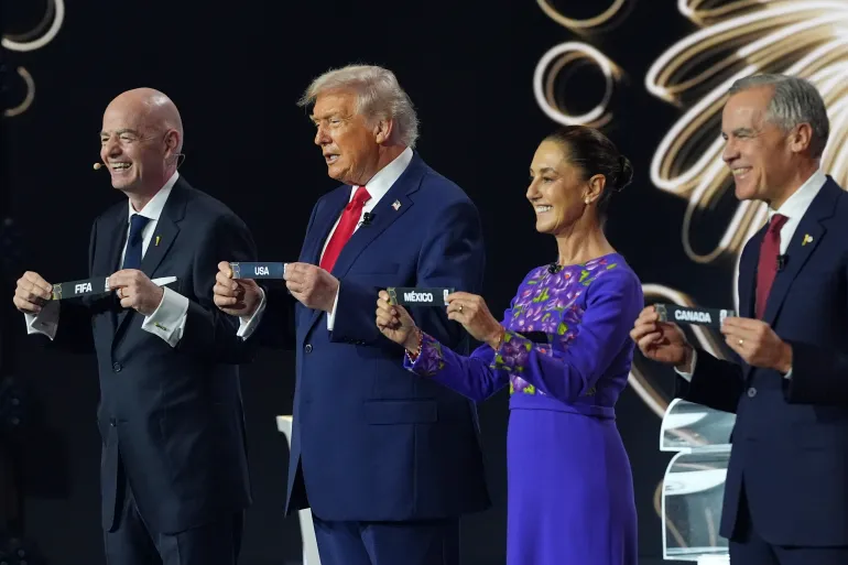 Canadian Prime Minister Mark Carney, Mexican President Claudia Sheinbaum, President Donald Trump and FIFA President Gianni Infantino hold up country names during the draw [Jacquelyn Martin/AP]