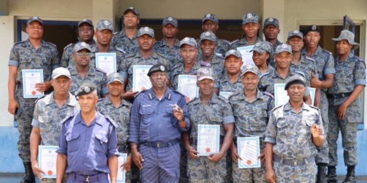 Senior Assistant Commissioner of Police Vusumuzi Gama, representing the National Commissioner, pictured with the twenty officers who completed the twelve week OSSU basic training programme. Photo by REPS