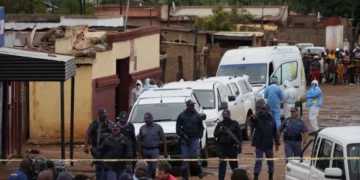 South African police gather at the scene of a mass shooting where gunmen killed nine and injured at least 10 in a pub in Bekkersdal, South Africa, Sunday, Dec. 21, 2025. Alfonso Nqunjana/AP