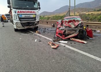 A truck and a car lie damaged after a collision on a busy road