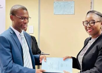 Commission Chairperson Zandile Mkhwanazi-Dhlamini presents the Hlathikhulu Town Board inquiry report to Minister of Housing and Urban Development Appolo Maphalala in Mbabane.