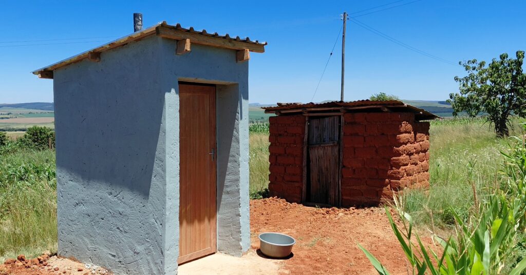 A modern toilet facility built as part of the housing project is seen alongside the old toilet previously used by the beneficiary family in the area. Photo: Deputy Prime Minister’s Office