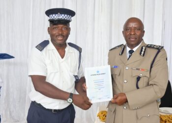 Senior Assistant Commissioner of Police Mr Vusi Gama presents a certificate to one of the officers who completed the Police Practice and Law Course at Matsapha Police Academy.