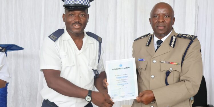 Senior Assistant Commissioner of Police Mr Vusi Gama presents a certificate to one of the officers who completed the Police Practice and Law Course at Matsapha Police Academy.
