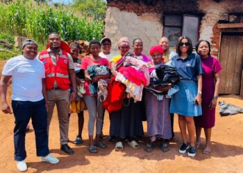 Deputy Prime Minister’s Office team and Baphalali Eswatini Red Cross volunteers pose with families during the clothing and footwear distribution under the Asibambeni Sibe Ngumdeni program in Hhohho.