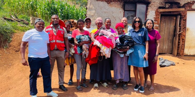 Deputy Prime Minister’s Office team and Baphalali Eswatini Red Cross volunteers pose with families during the clothing and footwear distribution under the Asibambeni Sibe Ngumdeni program in Hhohho.