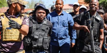 Xolani Khumalo, in blue, flanked by members of his security detail, arriving at Palm Ridge Magistrates’ Court last month on charges related to a December 2025 drug-bust operation. (Photo: OJ Koloti / Gallo Images)
