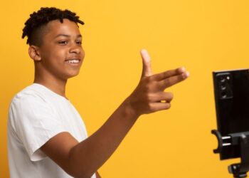 Side view smiley teen recording video Photo by freepik