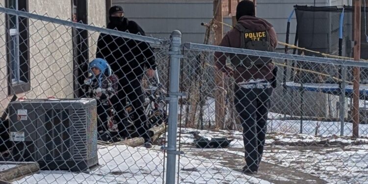 ICE agents stand next to a boy, who a witness identified as Liam Conejo Ramos, a five-year-old that school officials said was detained in Minneapolis, Minnesota, U.S., January 20, 2026. Rachel James/via REUTERS