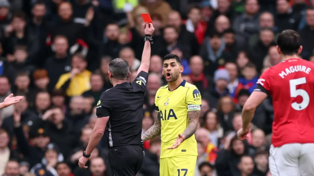 Tottenham Hotspur captain Cristian Romero reacts after being shown a straight red card by the referee for a foul on Casemiro during the Premier League match at Old Trafford.