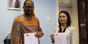 Principal Secretary Sibusiso Nkambule and Kato Asuka, Programme Director from the Japan International Cooperation System, hold the signed MoU for the Universal School Transport Project.